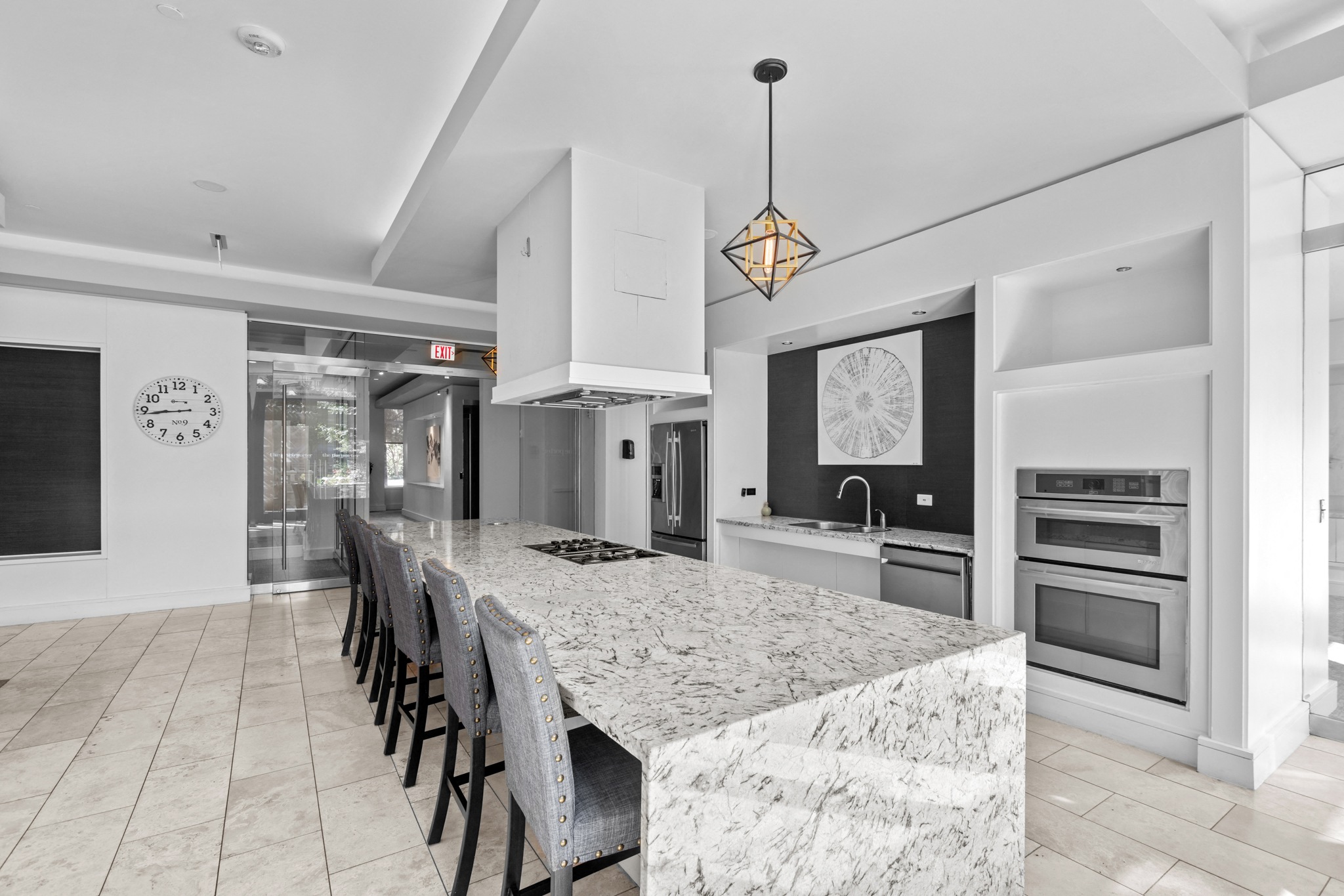 the kitchen has a large island with granite countertops and a long table with chairs